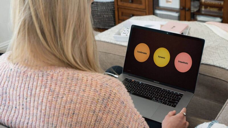 A person looks at their laptop during a presentation.