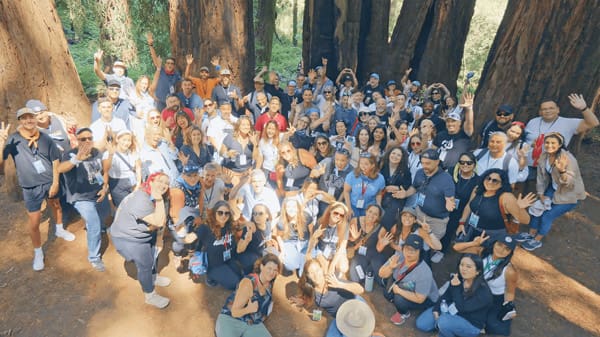 very large group of people huddled together for photo at an event