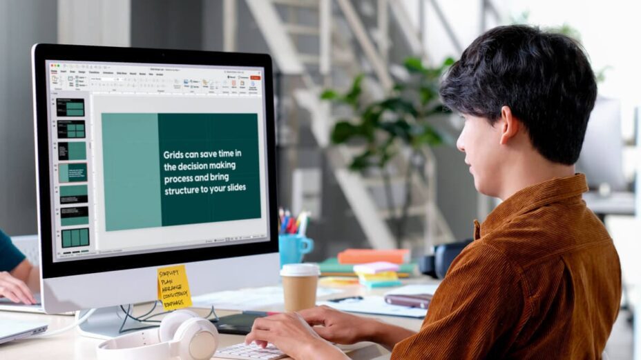 A person sits at a computer while editing presentation slides.