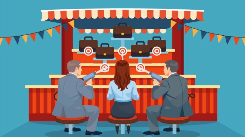 Three business professionals seated at a midway style game where players aim water cannons at a target although here briefcases are mounted and moving towards the finish line. This is meant to symbolize how leadership development can support succession planning.