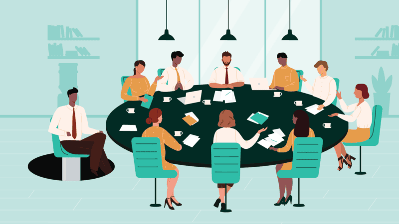 A group of executives are seated around a board room table as a another team member emerges through the floor on a chair to join them. This barber chair image is meant to signify how leadership development programs can support employee retention by giving folks a seat at the table.